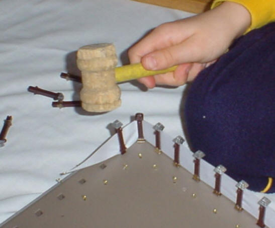 Photo demonstrating tapping in the post in the tabernacle kit fence