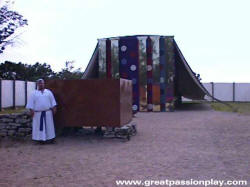 Great passion Play image of priest standing by the altar in front of the Tabernacle model